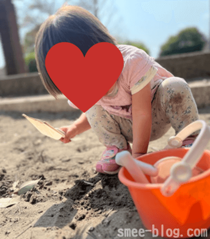 2歳児が砂場遊びをしている